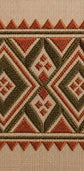 Close-up of a woven textile with a geometric embroidered pattern in rust orange, olive green, and cream.

