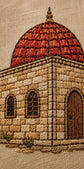 Close-up of an embroidered architectural scene showing a domed stone building with arched windows and door on a beige fabric background.

